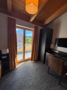 a room with a television and a large window at Boutique & Wellnesshotel Thalmässing in Thalmässing