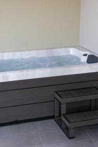 a hot tub with a bench in front of it at MV Living - Retreat in Daratso
