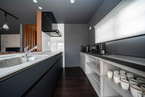a kitchen with a sink and a counter with cups at Violet Garden in Furano