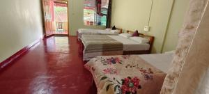a room with three beds in a room at Nisarga Coorg Home Stay in Somvārpet