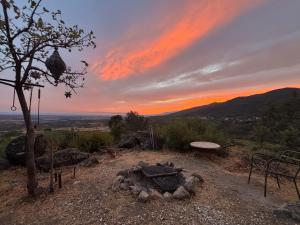 a fire pit with a sunset in the background at El Encuentro - Casa Rural - in Arenas de San Pedro
