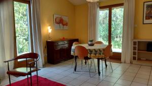 a dining room with a table and chairs and windows at Gite Mimosa - Private Pool, Sainte-Valière, South of France in Sainte-Vallière
