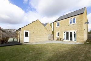 a large brick house with a patio in the yard at Wren House in Ambrosden
