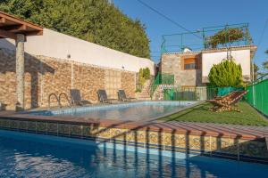 a swimming pool in front of a house at El Aguacate in Lanjarón
