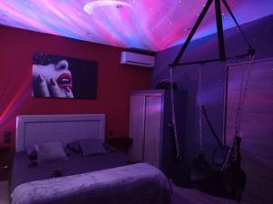 a bedroom with a bed with a pink and purple ceiling at L'Envol de Séléné - LOVE ROOM in Carcassonne
