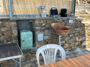 a stone wall with a table and a table and chairs at Appartamento fronte mare in Poggi