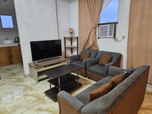 a living room with a couch and a tv at Grand Mercy Hotel in Calbayog City