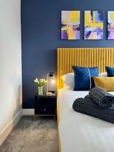 a bedroom with a bed with blue and yellow pillows at Luxury Norwich City Centre Apartment - Free Parking in Norwich +15 photos