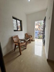 a room with two chairs and a table and a window at Om Ganesh Guest House1 in Arambol