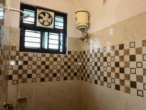 a bathroom with a shower with a clock on the wall at Hotel Cz Inn in Lucknow