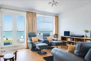 a living room with a couch and chairs and a large window at The Hamptons - Entire Seafront Property with Stunning Sunsets in Herne Bay