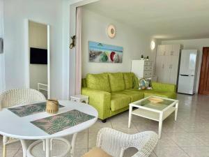 a living room with a green couch and a table at Doñana 16 in Patalavaca