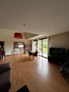 a living room with a couch and a television and a table at Espaciosa con vistas in Villaviciosa