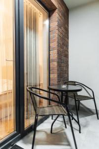 two chairs and a table in front of a window at Nest Inn Velvet Apartment in Baia Mare