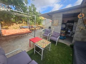 a patio with a hammock and chairs and a table at בית קרקע לנופש עם חצר גדולה במרכז קרית שמונה in Qiryat Shemona