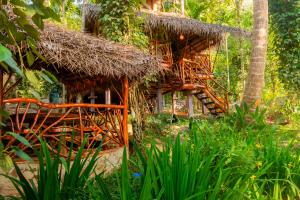 a small hut with a straw roof at Wooden Eco Cottage in Katiyawa