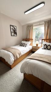 a bedroom with two beds and a window at Modern 2Bedroom House in Coventry Private Parking in Coventry