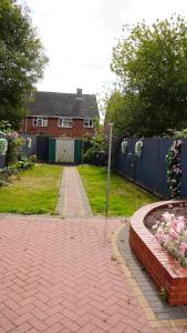 a brick yard with a house and a fence at Modern 2Bedroom House in Coventry Private Parking in Coventry