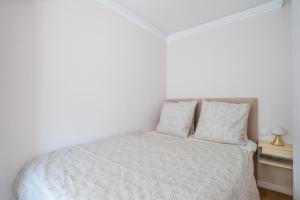 a white bedroom with a bed and two pillows at appart terrasse 1 mn de la plage in Nice