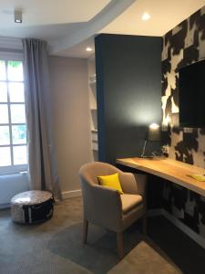 a office with a chair and a desk with a yellow pillow at Logis Auberge De La Riviere in Velluire