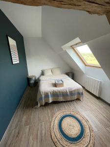 a bedroom with a bed and a rug on the floor at En plein cœur de la Sologne in Courmemin