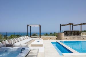 a swimming pool with white chairs and a swimming tub at Alpha Estate & Spa in Rethymno Town +73 photos