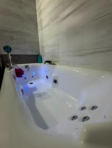 a white bath tub with a red rose in it at LUX Apartament in Suwałki +11 photos