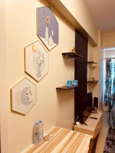 Una habitación con un escritorio y algunos cuadros en la pared. en Iloilo Staycation, en Iloilo City
