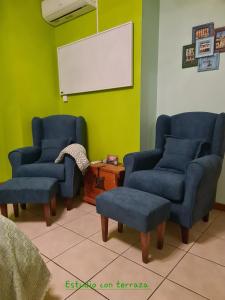 una sala d'attesa con due sedie blu e una lavagna bianca di Die kleine Auszeit a Denia