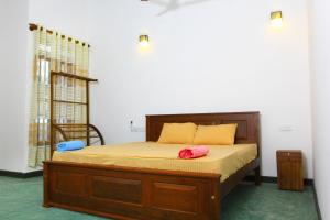 ウェリガマにあるRoxie Guestのベッドルーム1室(木製ベッド1台、枕2つ付)