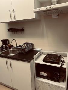 Una pequeña cocina con fregadero y estufa. en Iloilo Staycation, en Iloilo City 1 foto más