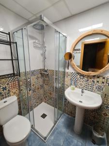 a bathroom with a toilet and a sink and a mirror at Die kleine Auszeit in Denia