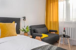 un dormitorio con una cama y una silla en Gliwicka Premium Apartament z balkonem, en Rybnik