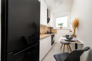 Una cocina con un refrigerador negro y una mesa. en Gliwicka Premium Apartament z balkonem, en Rybnik 7 fotos más
