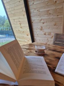 Ein offenes Buch liegt neben einer Tasse Kaffee auf einem Tisch. in der Unterkunft Borlova Frame in Borlova