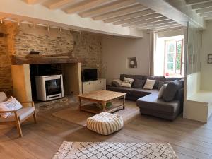 een woonkamer met een bank en een tafel bij La Maison Rose in Saint-Armel