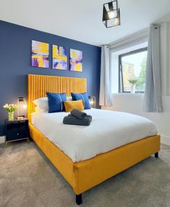 a bedroom with a large bed with blue walls at Luxury Norwich City Centre Apartment - Free Parking in Norwich