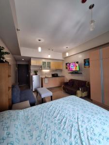 ein Schlafzimmer mit großem Bett und ein Wohnzimmer in der Unterkunft Eastwood Legrand3 Studio Type condo in Manila