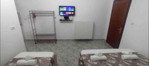 a room with two beds and a tv in it at Kruti house in Përmet
