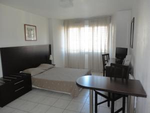 a bedroom with a bed and a desk and a table at Residhotel Cannes Festival in Cannes