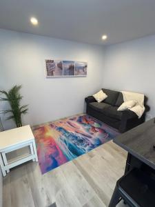 a living room with a couch and a colorful rug at Cozy guest suite in Margate, 200 mts from beach in Woody Point