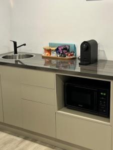 a kitchen counter with a microwave and a sink at Cozy guest suite in Margate, 200 mts from beach in Woody Point