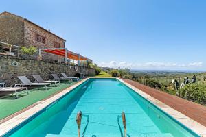 une piscine avec des chaises et un bâtiment dans l'établissement Resort Esclusivo di Vinci, à Vinci