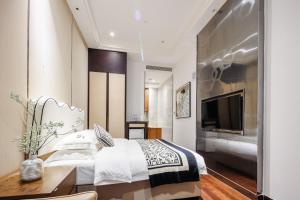 a bedroom with a bed and a desk and a television at SEEU Designer Apartment in Shenzhen
