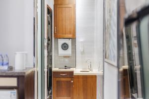 a kitchen with a sink and a clock on the wall at SEEU Designer Apartment - Qiaoxiang Metro, Futian Shenzhen in Shenzhen +133 photos
