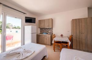 a kitchen with a bed and a table and a refrigerator at Hotel Elisabeta Borsh in Borsh +114 photos