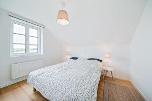a white bedroom with a bed and a window at Maison MadArt surround yourself in nature in Oizy