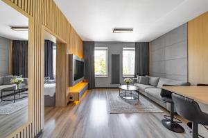 a living room with a couch and a table at SKY Home- Piwna Wood -Manufaktura, Parking, Dostęp na Kod in Łódź