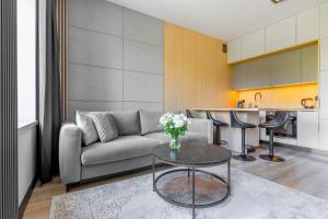 a living room with a couch and a table at SKY Home- Piwna Wood -Manufaktura, Parking, Dostęp na Kod in Łódź