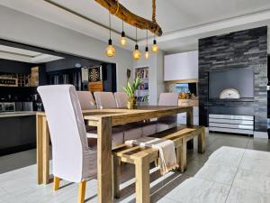 a dining room with a wooden table and chairs at 1442 Marina by Double Portion in Jeffreys Bay